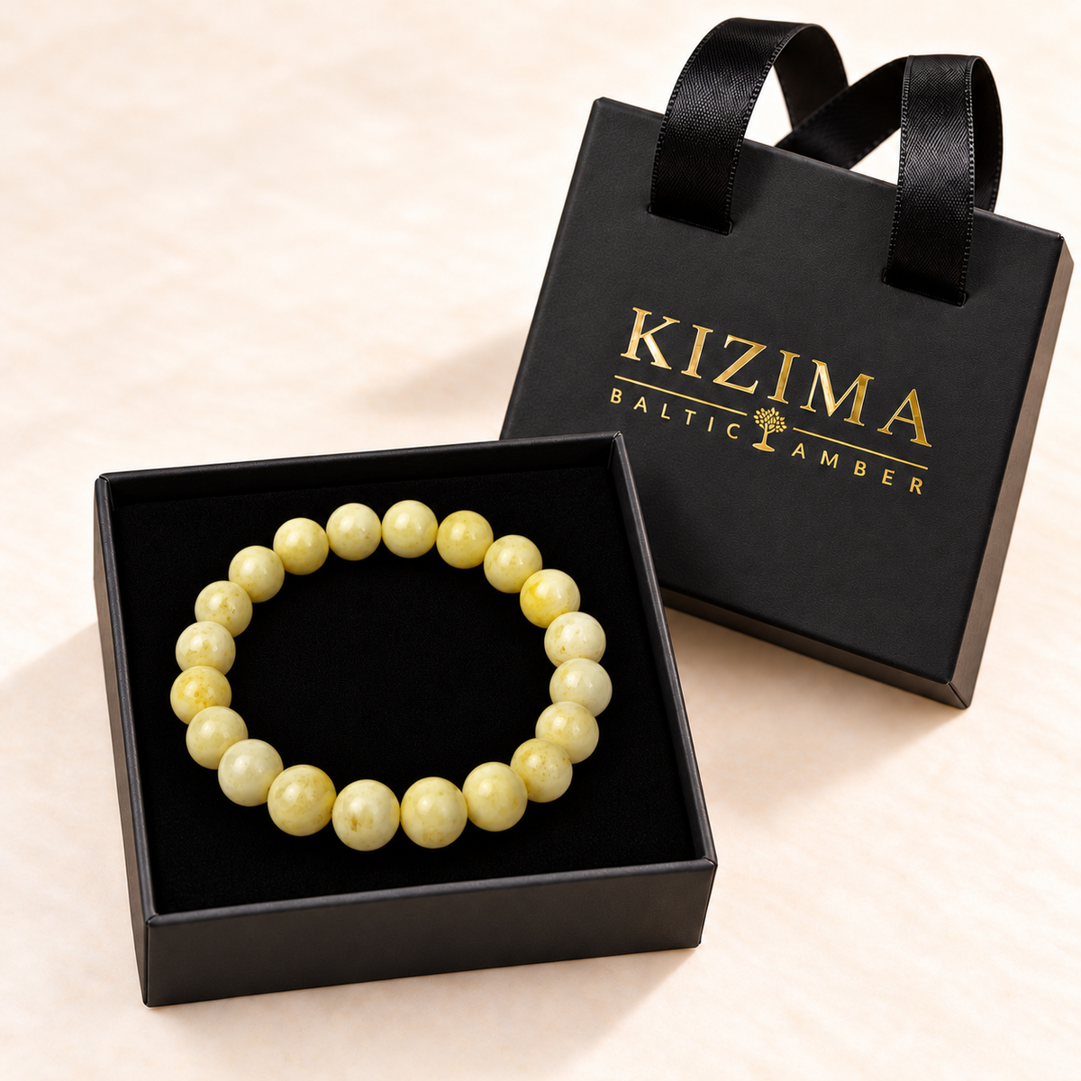 White Baltic amber round-bead bracelet displayed on clean black velvet in a KIZIMA gift box.