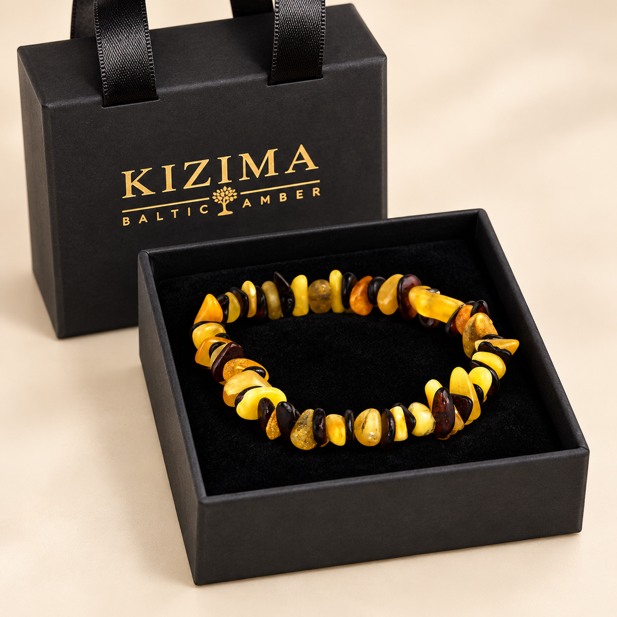 Yellow and dark cherry amber chip bracelet on clean black velvet inside a KIZIMA gift box.