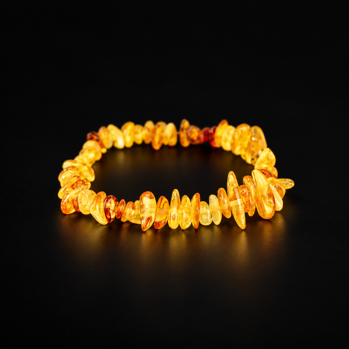 KIZIMA translucent yellow and honey amber chip bracelet on a black studio background.