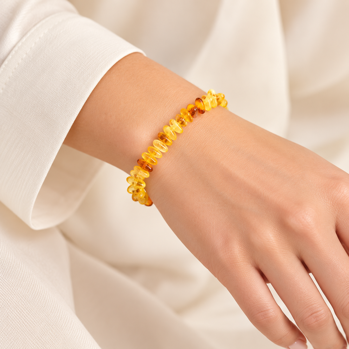 KIZIMA translucent yellow and honey amber chip bracelet on a young adult woman's wrist.