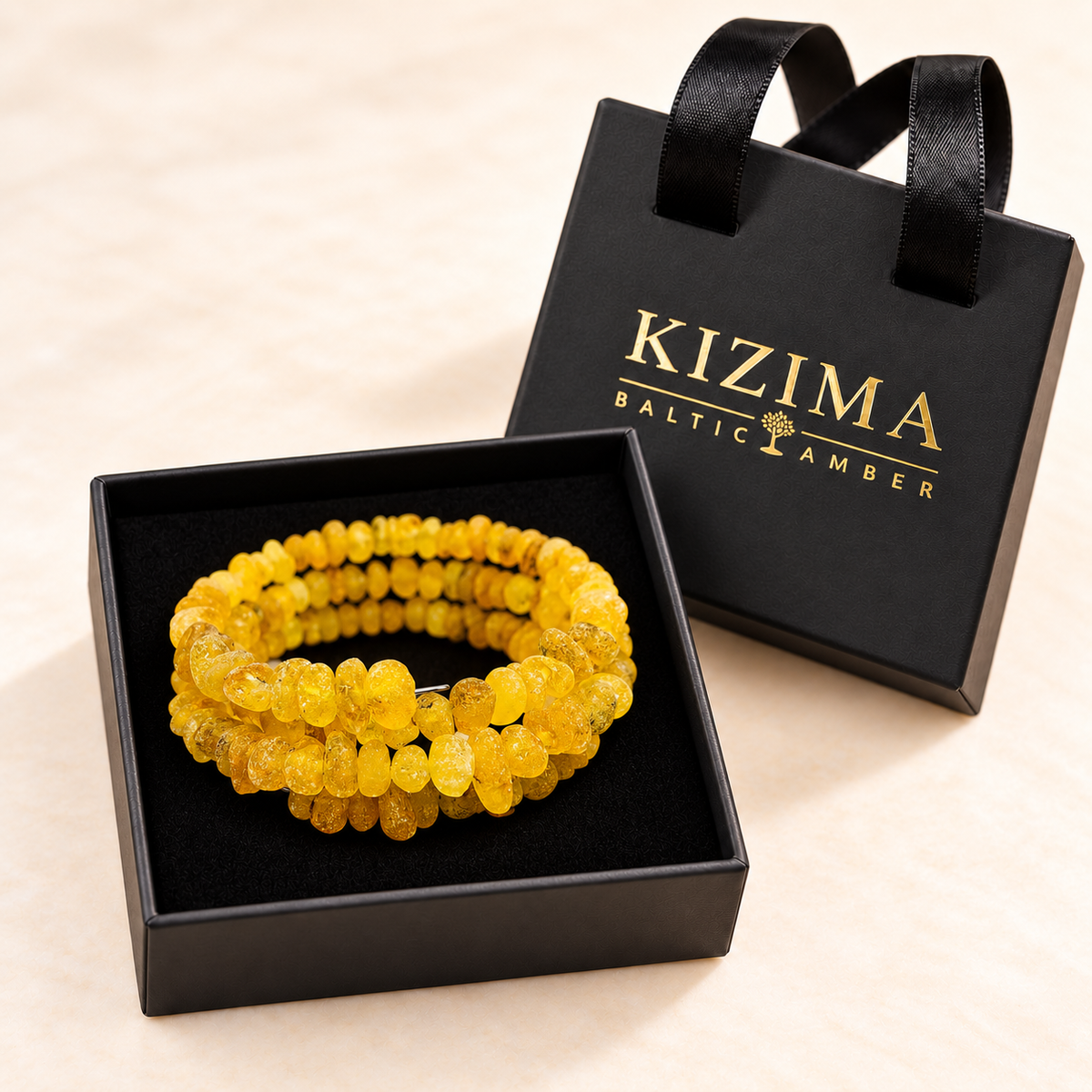 KIZIMA frosted yellow amber three-coil wrap bracelet inside a black KIZIMA gift box.