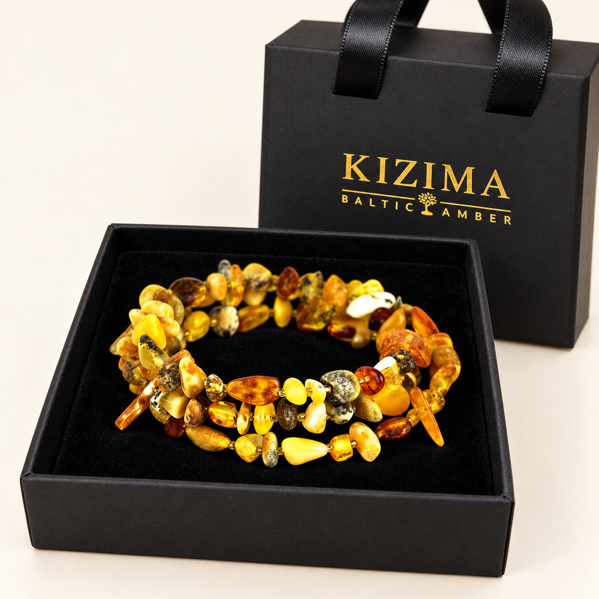 Multicolor Baltic amber spiral bracelet on pristine black velvet in a KIZIMA gift box.