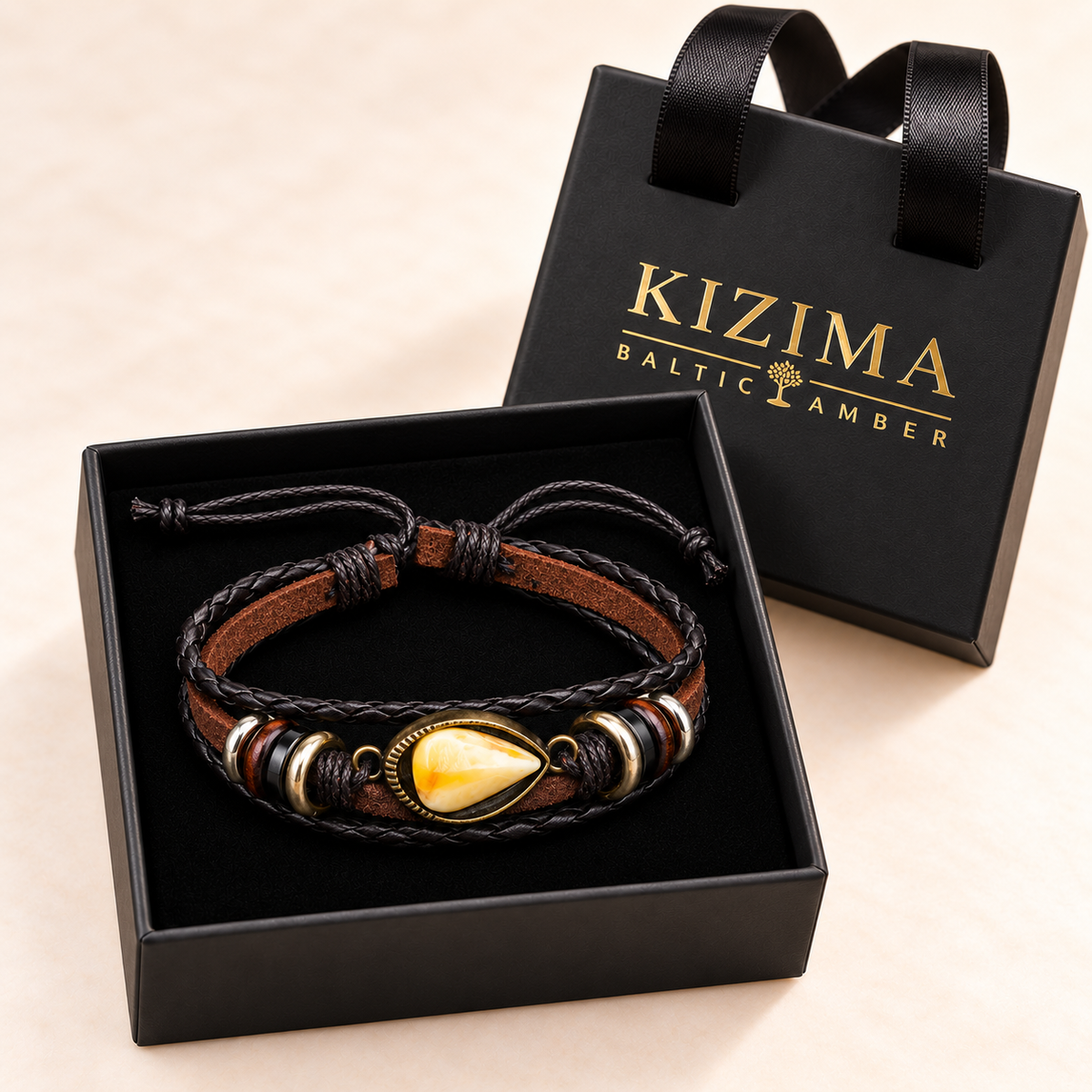 Amber teardrop leather bracelet arranged on pristine black velvet inside the KIZIMA gift box.