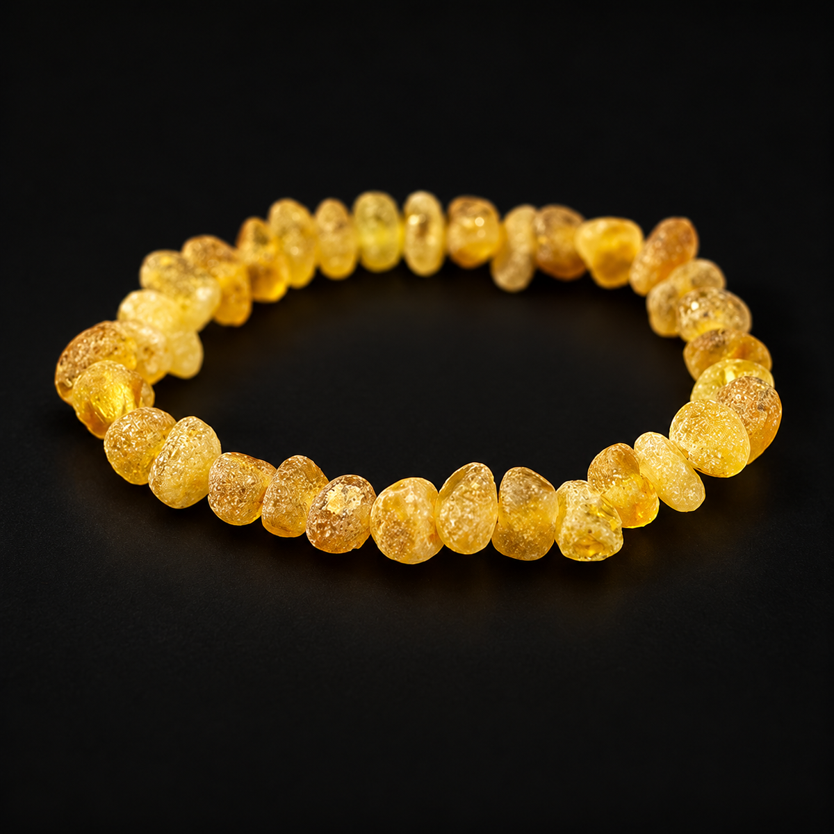 KIZIMA raw honey-yellow amber nugget stretch bracelet in premium black studio light.