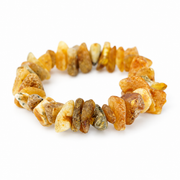 Irregular frosted amber chips with natural rough surfaces in a stretch bracelet on white.