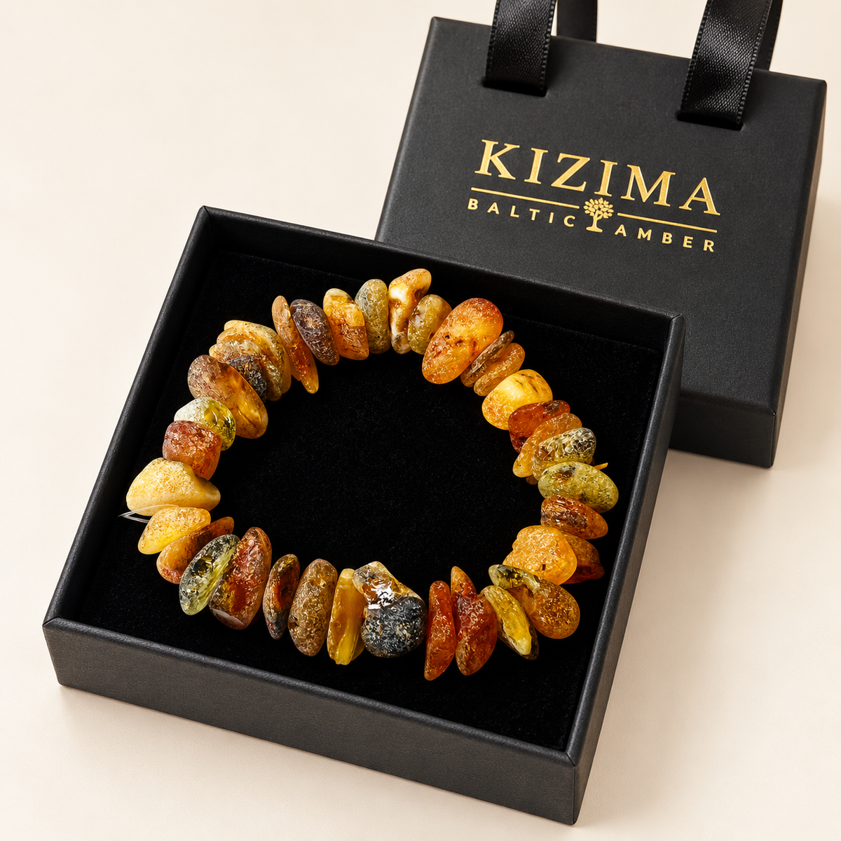 KIZIMA 3N0150q17.16 natural amber chip bracelet with varied honey and mottled tones on clean black velvet in its KIZIMA gift box