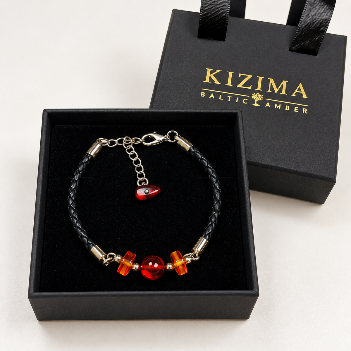 KIZIMA cherry amber three-bead black braided leather bracelet in a KIZIMA gift box.