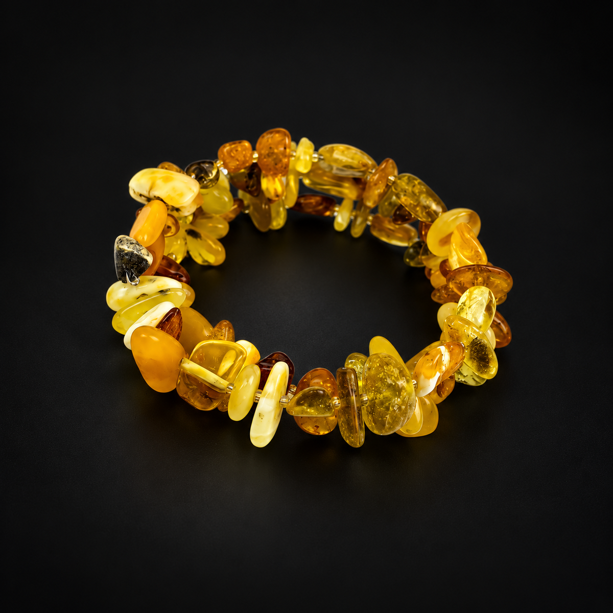 KIZIMA multicolor Baltic amber chip spiral bracelet in a premium black studio setting.