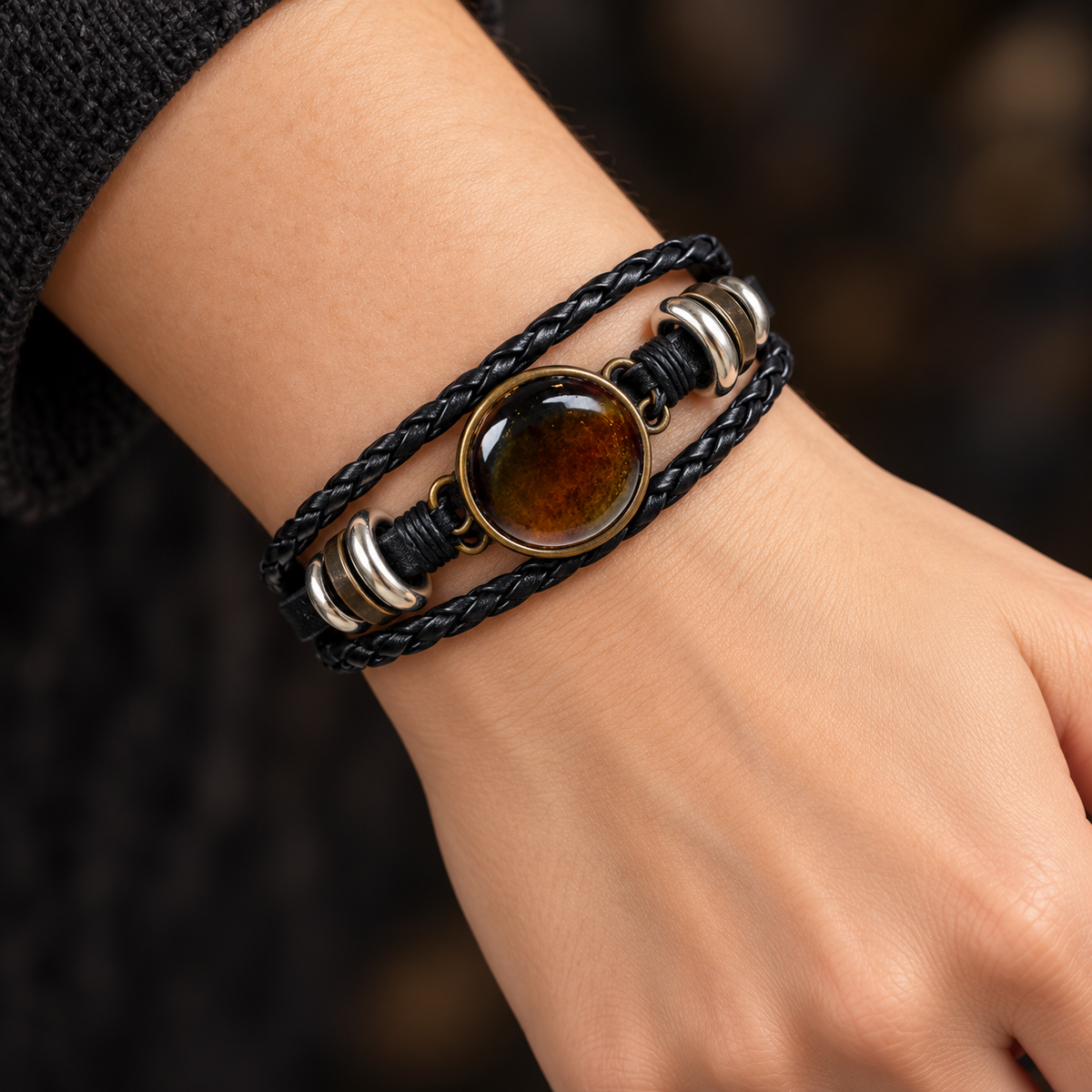 KIZIMA 3N0180q8.4 round cognac amber cabochon multi-strand black leather bracelet worn on an adult woman's wrist