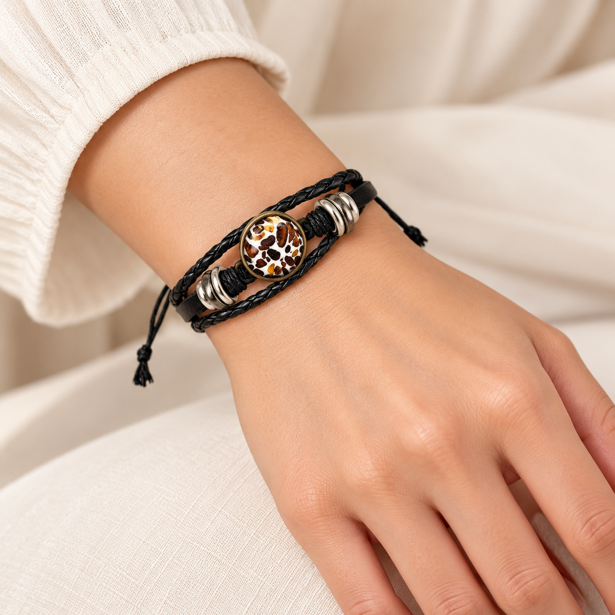 KIZIMA amber mosaic oval and black leather adjustable bracelet on a young adult woman's wrist.