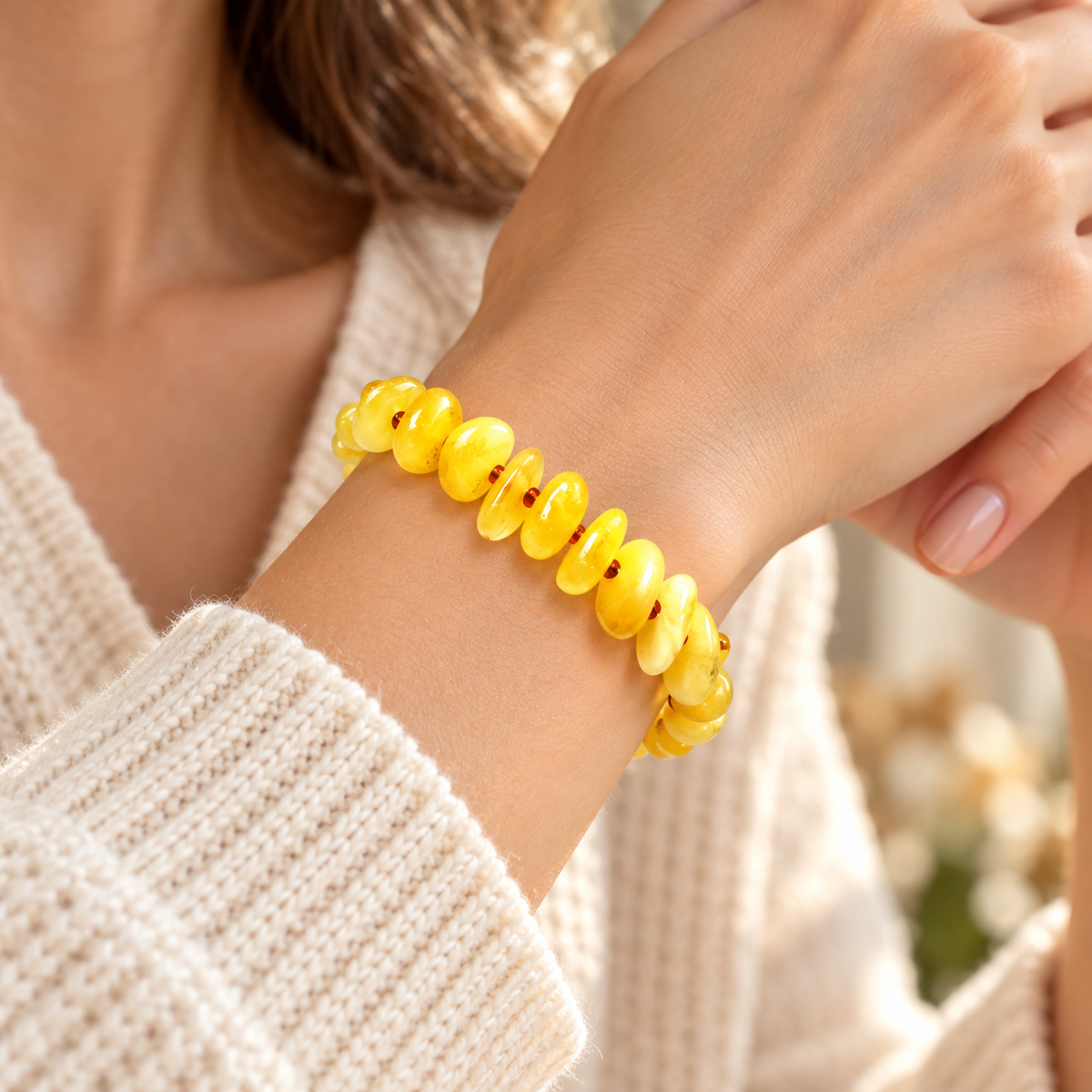 KIZIMA 3N0200q11.50 yellow amber chip bracelet with reddish-brown spacers worn on a woman's wrist
