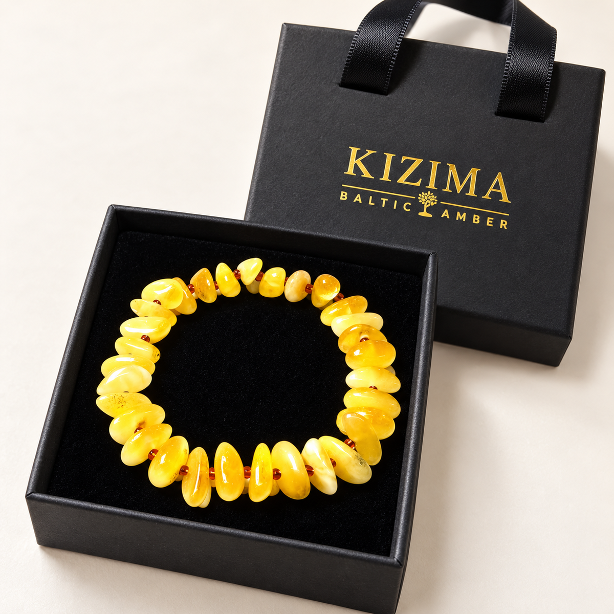KIZIMA 3N0200q11.50 yellow amber chip bracelet with reddish-brown spacers on clean black velvet in its KIZIMA gift box