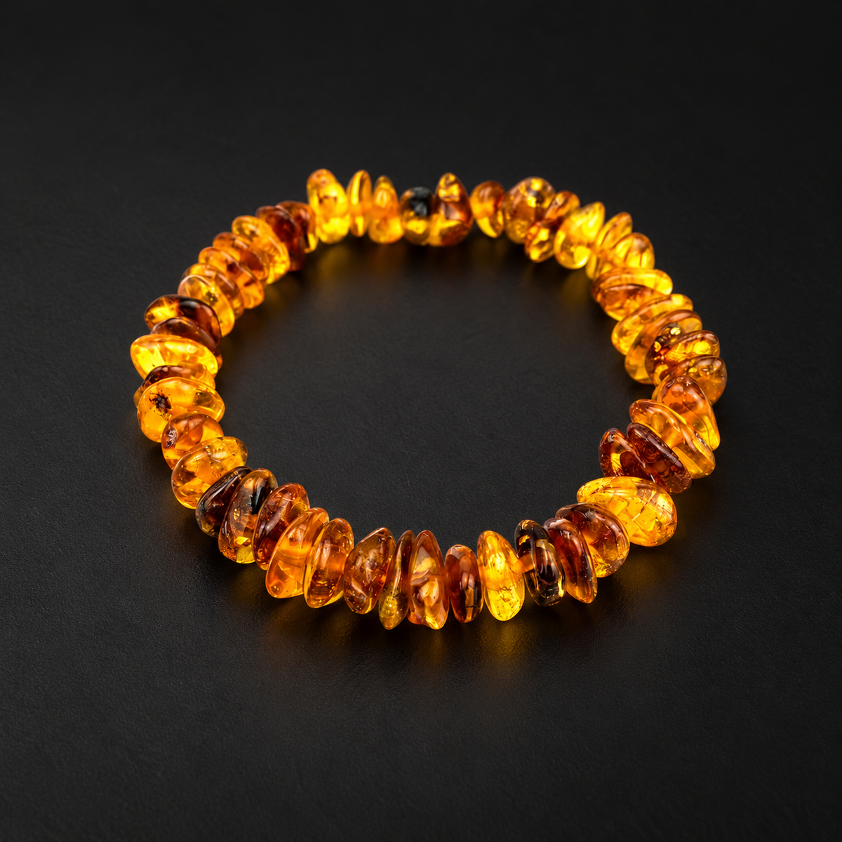 KIZIMA honey and cognac amber chip stretch bracelet photographed on a black studio surface