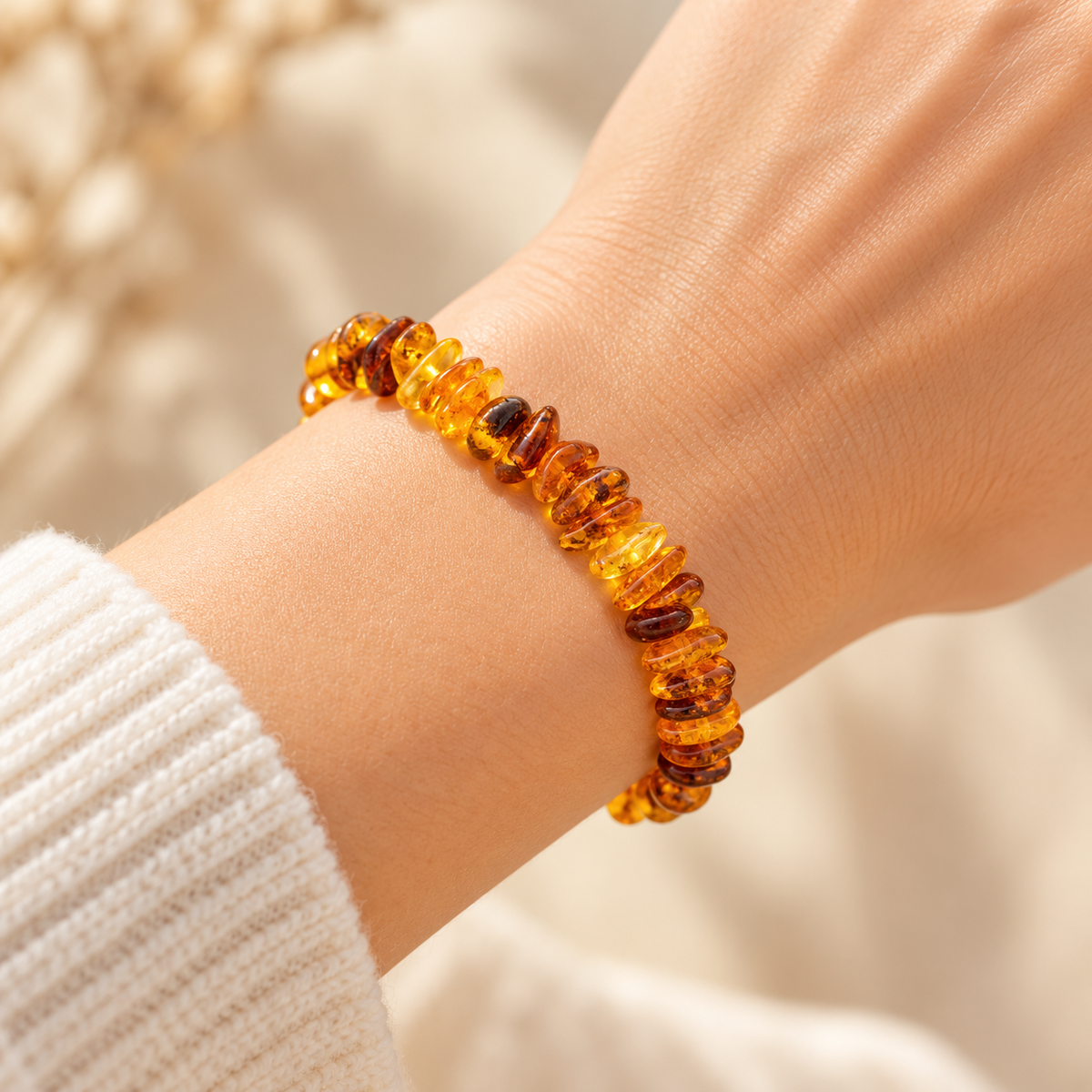 Honey and cognac amber chip bracelet worn on a woman's wrist in soft natural light