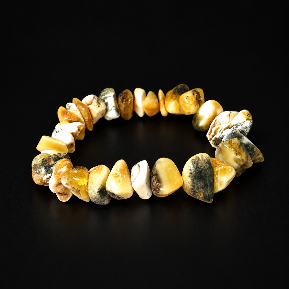 KIZIMA 3N0200q17.85 cream and mottled amber chip bracelet on a black studio surface
