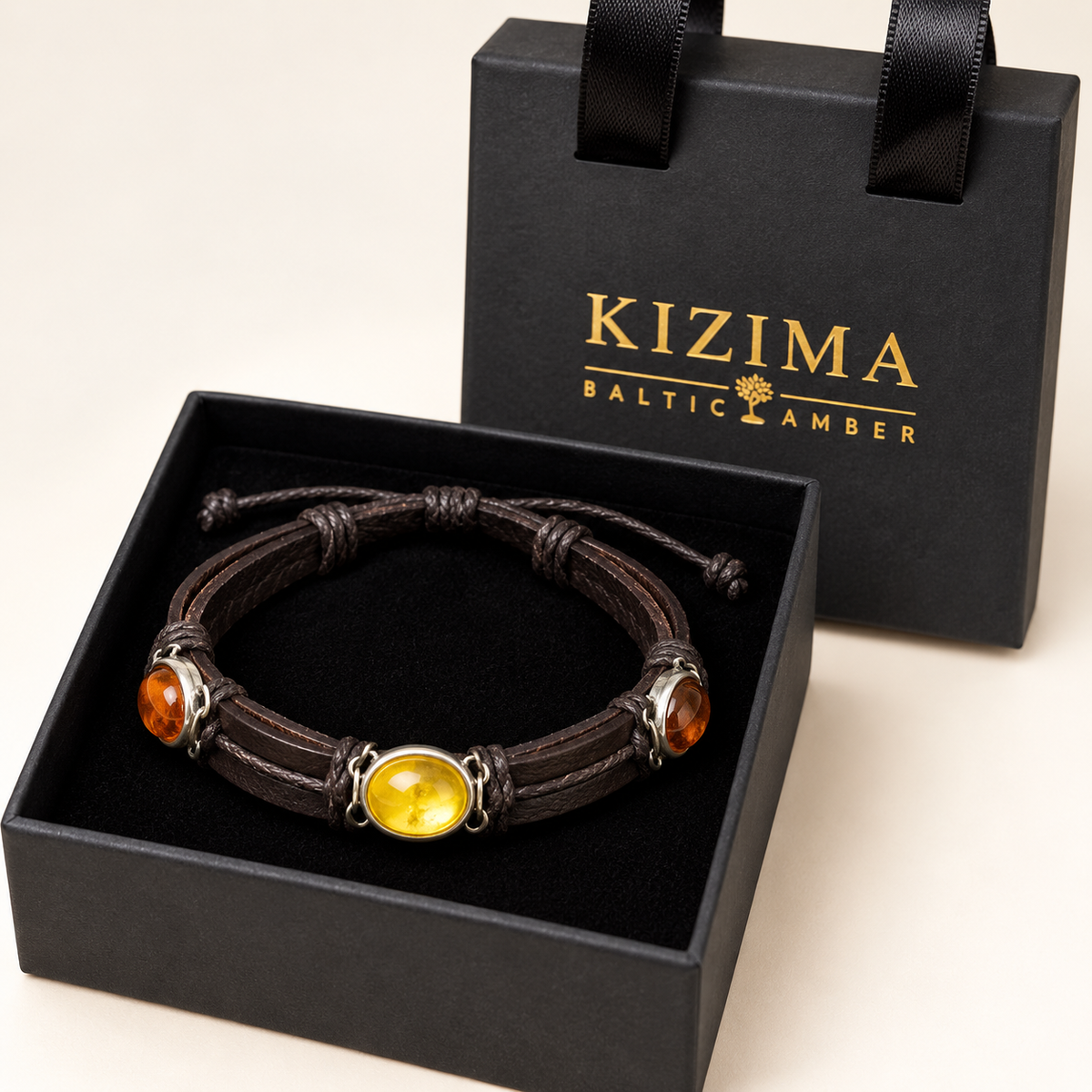 Amber and brown leather bracelet 3N0350mix resting in a black KIZIMA gift box with gold-branded handled lid
