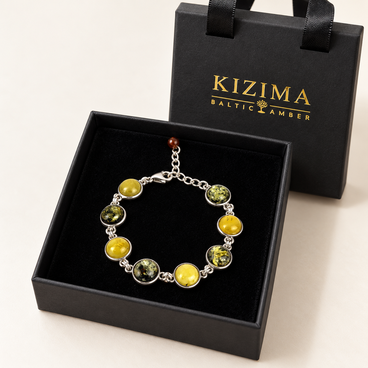 KIZIMA 3N0900q12-1.1 bracelet with eight alternating yellow and green amber cabochons displayed on clean black velvet in the KIZIMA gift box
