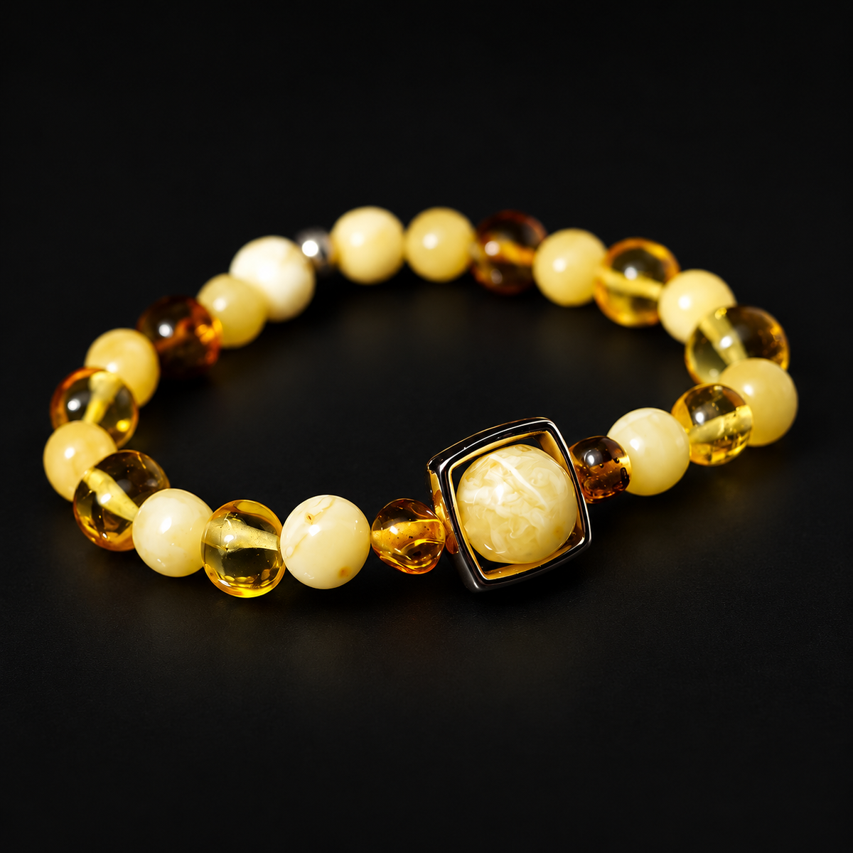KIZIMA cream and honey amber bracelet with a square-framed cream focal bead on black.