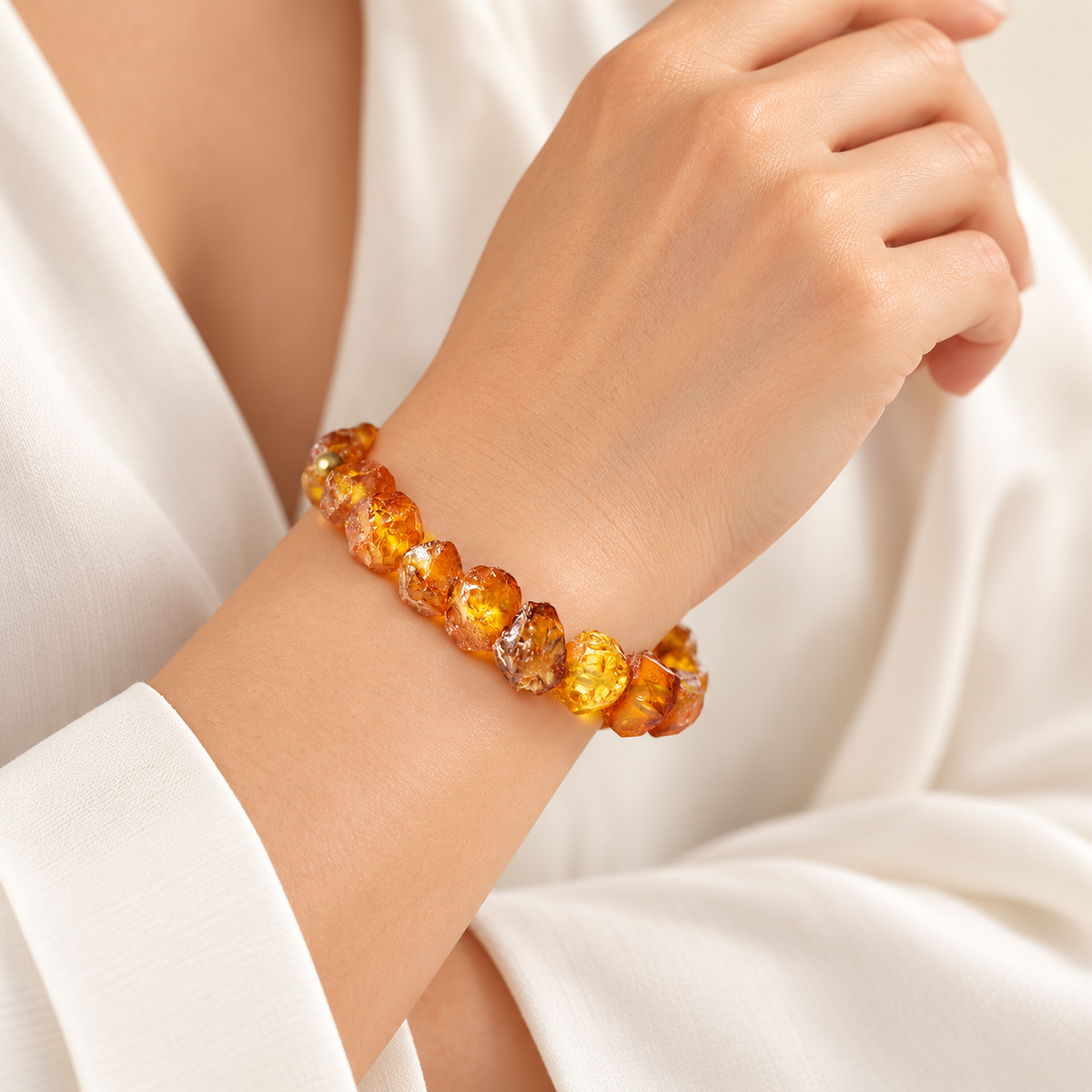 Faceted raw honey and cognac amber bracelet on a young adult woman's graceful wrist.