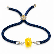 Adjustable navy rope bracelet with one faceted yellow amber stone on a white background