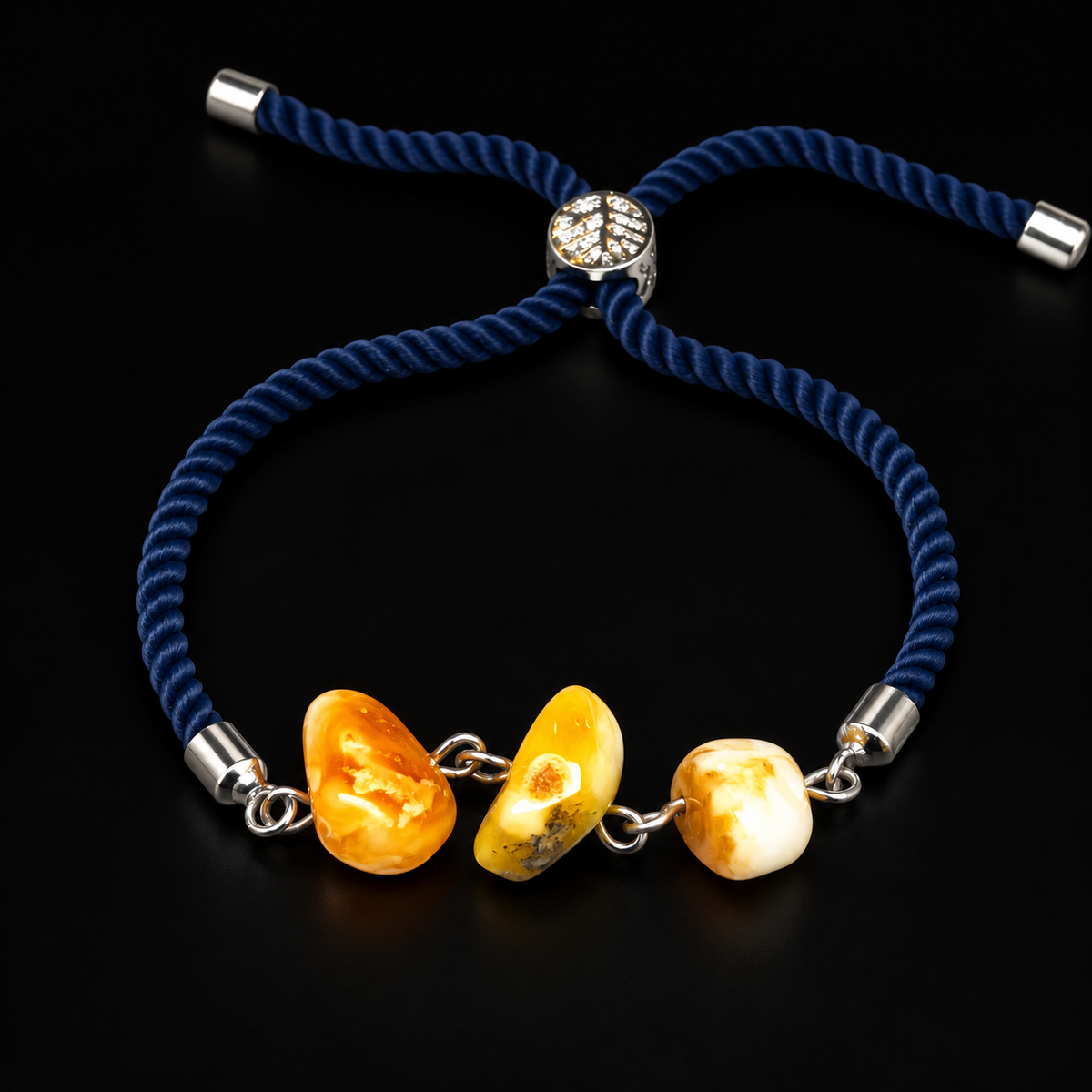 KIZIMA 3P0400q4.79 three-bead amber bracelet with navy rope cord and silver-tone fittings on black