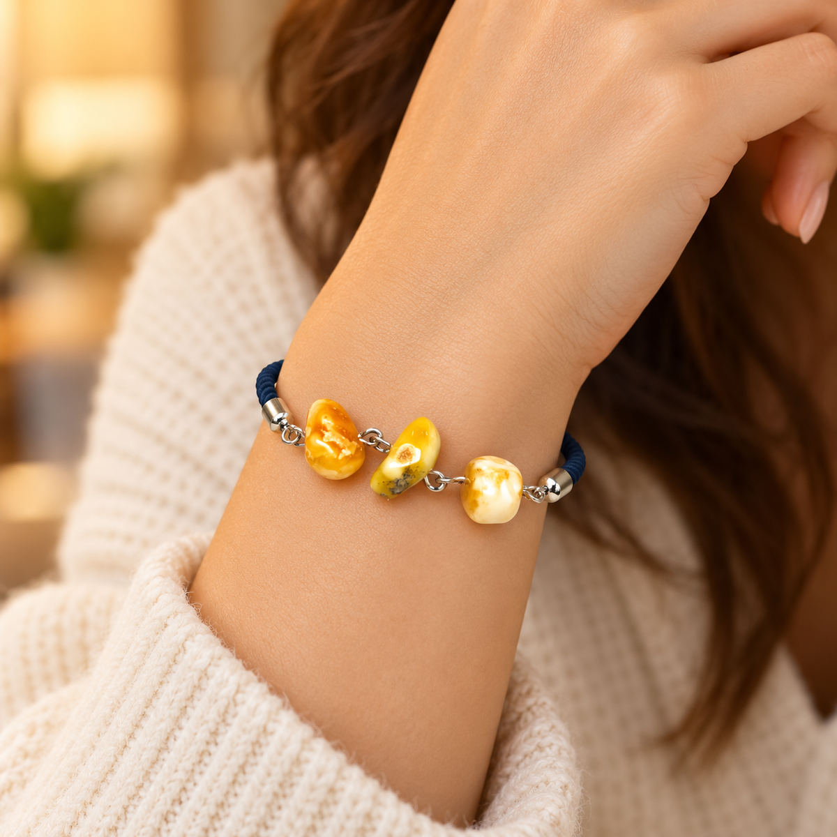 KIZIMA 3P0400q4.79 mixed-tone amber beads and navy cord worn around a woman's wrist