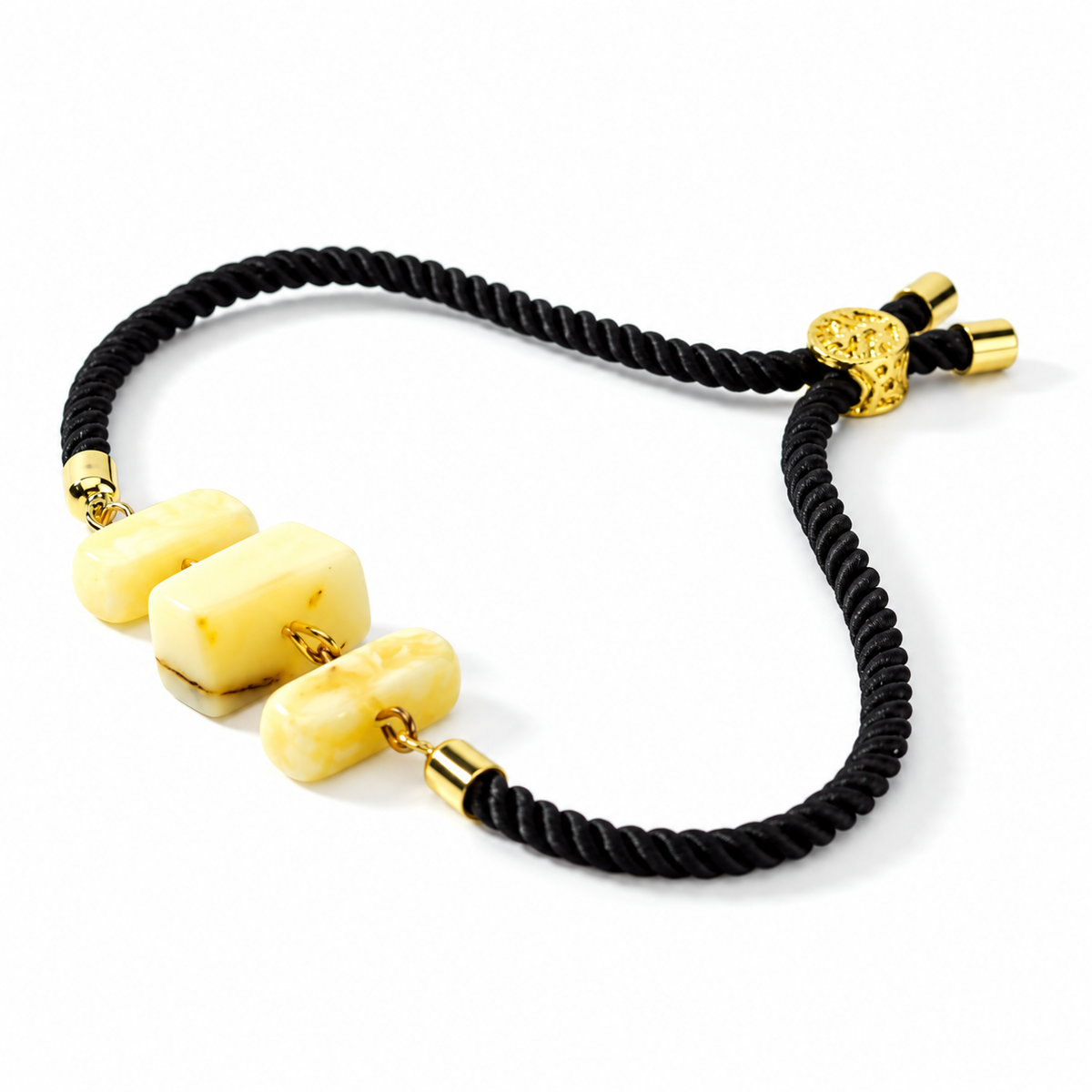 KIZIMA 3P0450q4.75 bracelet with three cream amber blocks and black cord isolated on pure white