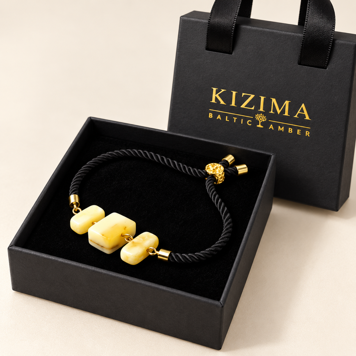 KIZIMA 3P0450q4.75 bracelet with three cream amber blocks and black cord on clean black velvet in the KIZIMA gift box