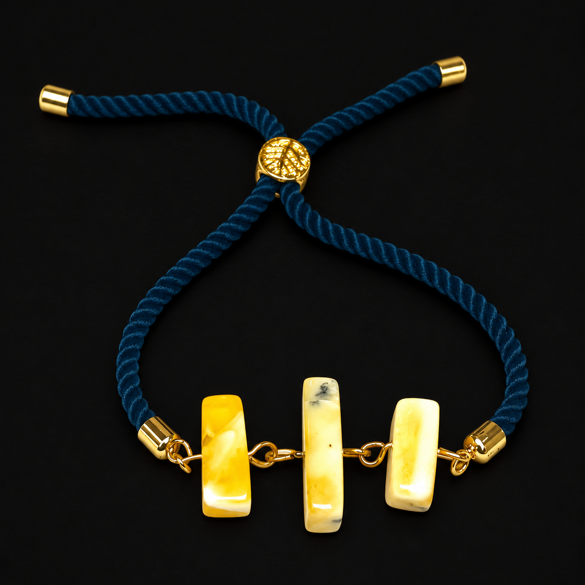 KIZIMA three creamy yellow amber bar bracelet with teal twisted rope and gold-tone fittings on black
