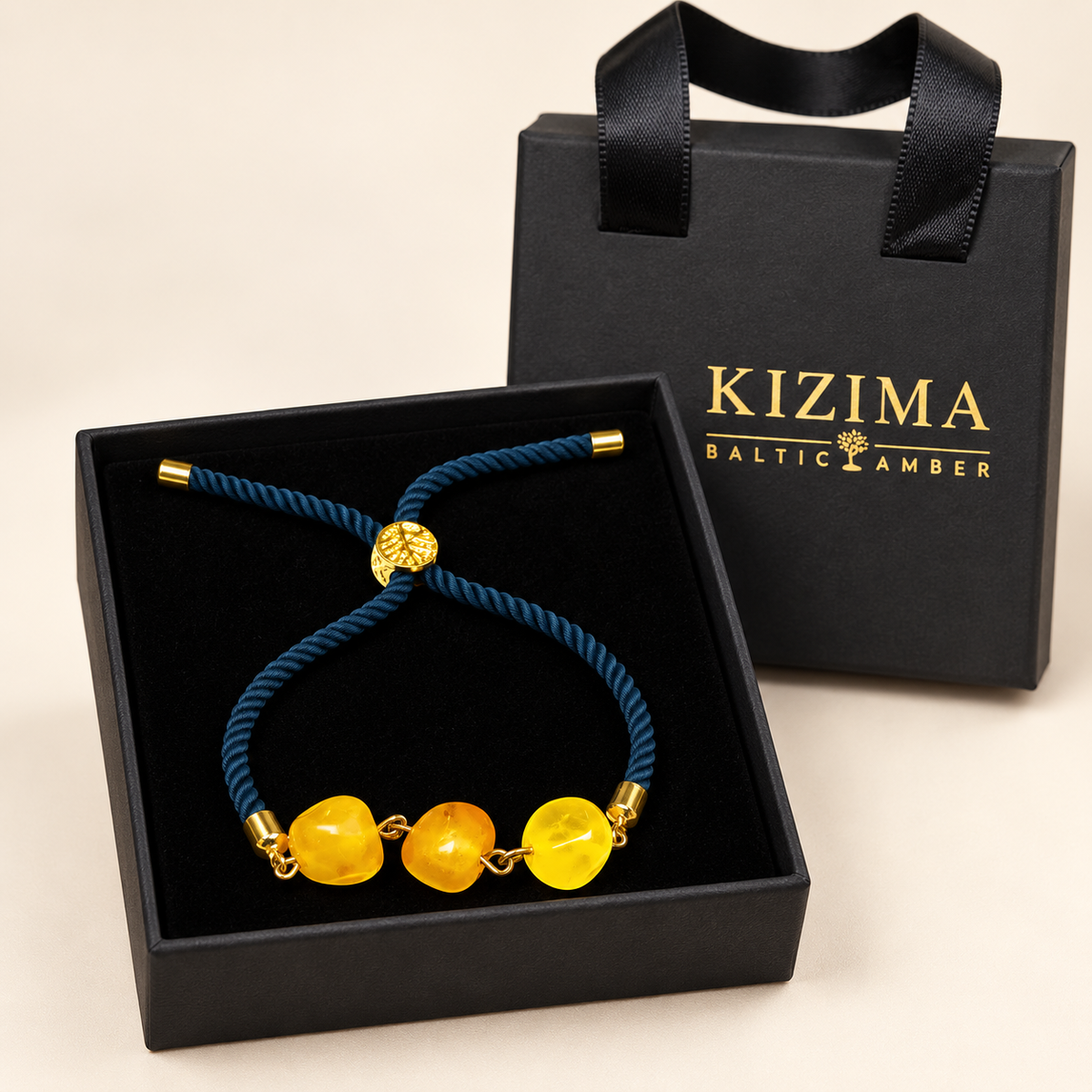 KIZIMA 3P0500q5.73 bracelet with three yellow amber beads and navy cord on clean black velvet in the KIZIMA gift box