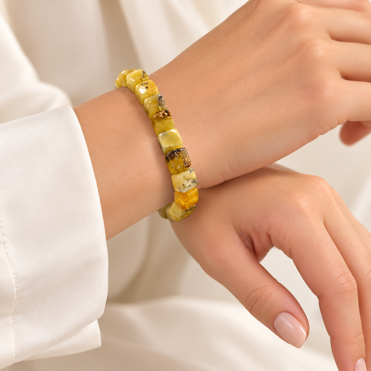 KIZIMA yellow amber cuboid bead bracelet with silver-tone clasp on a young adult woman's wrist.