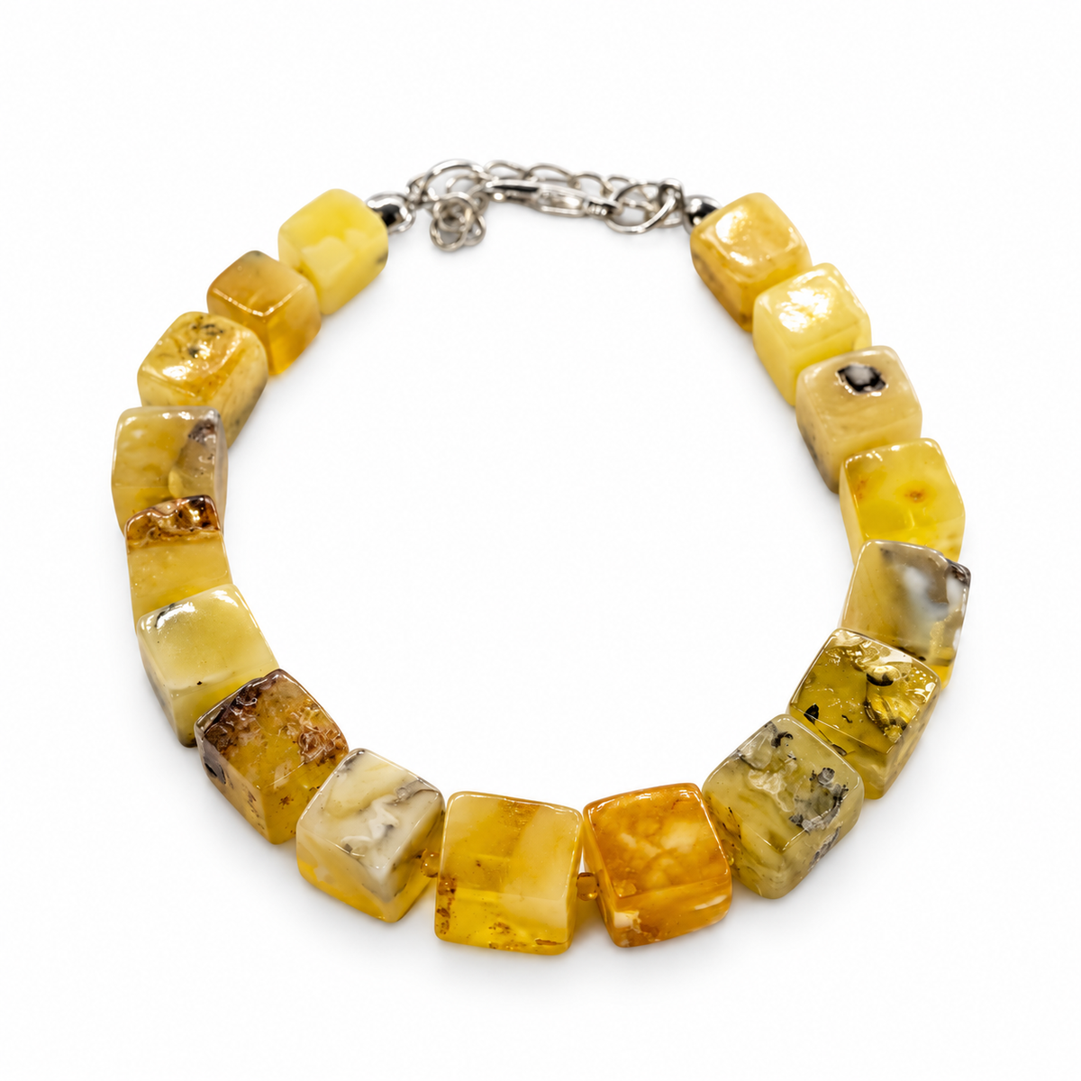Yellow and cream amber cube beads with dark natural inclusions and a silver-tone clasp on white.