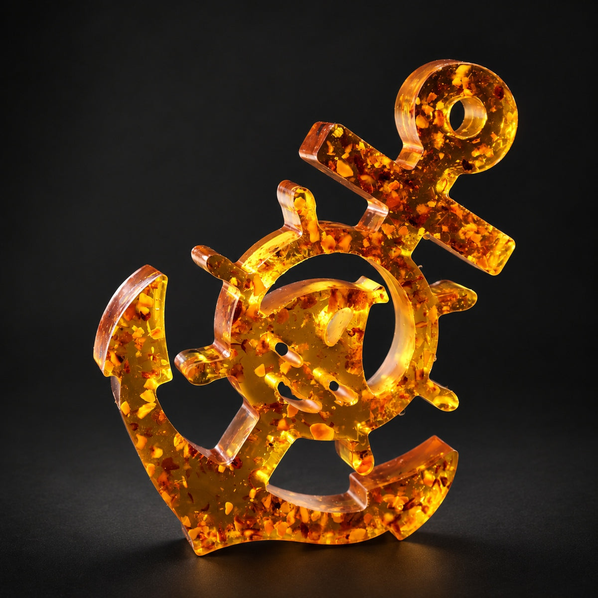 KIZIMA Baltic amber anchor with ship wheel and sailboat detail on a black background.