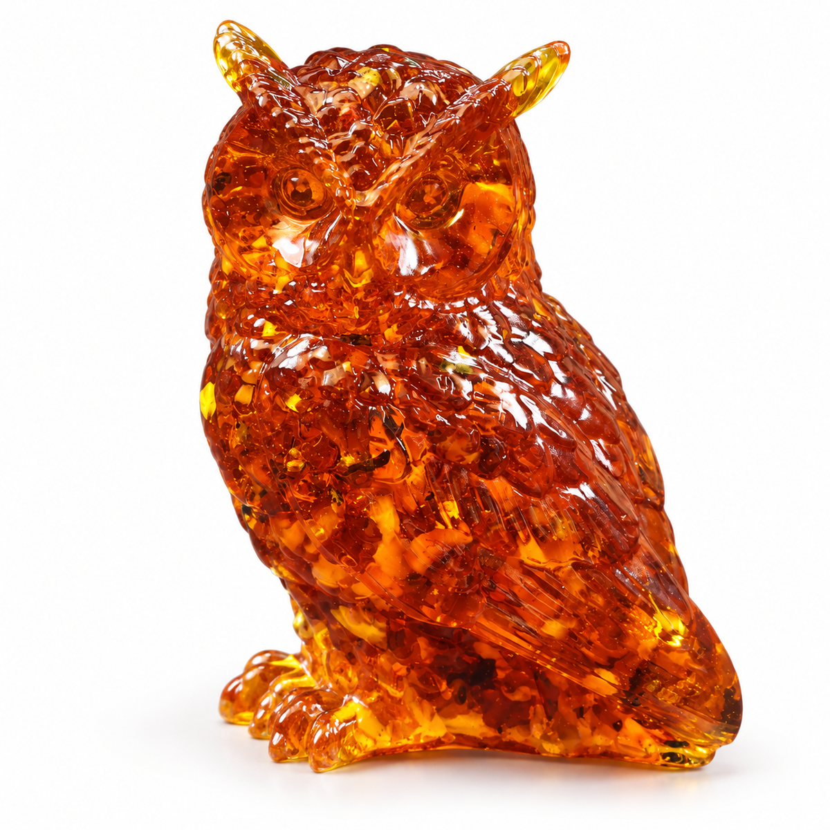 Glossy cognac amber owl shown at a three-quarter angle on white, with round eyes, detailed wings and visible golden fragments.