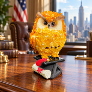 Made in USA natural Baltic amber mosaic graduation owl on a cap and diploma, on an oak desk in a Manhattan office.
