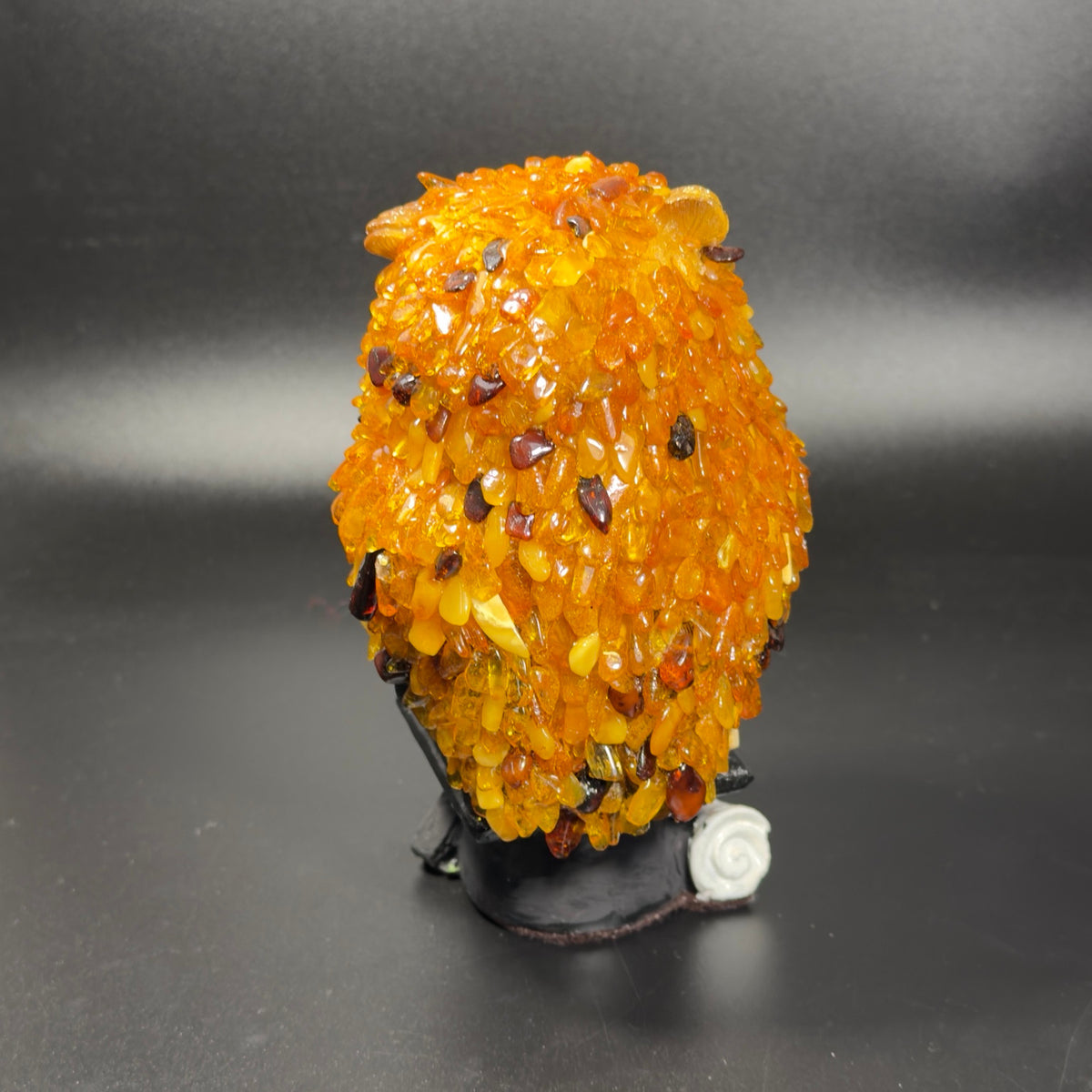 Rear view of the graduation owl showing hand-laid golden amber feathers with darker cognac accent stones.