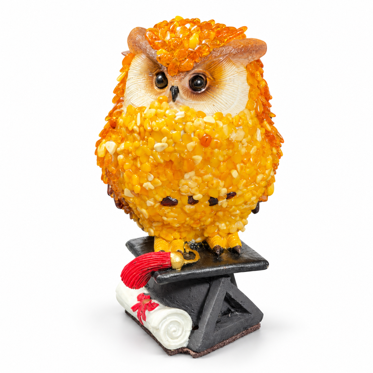 Three-quarter view of the handmade amber graduation owl and graduation-cap base on a white background.
