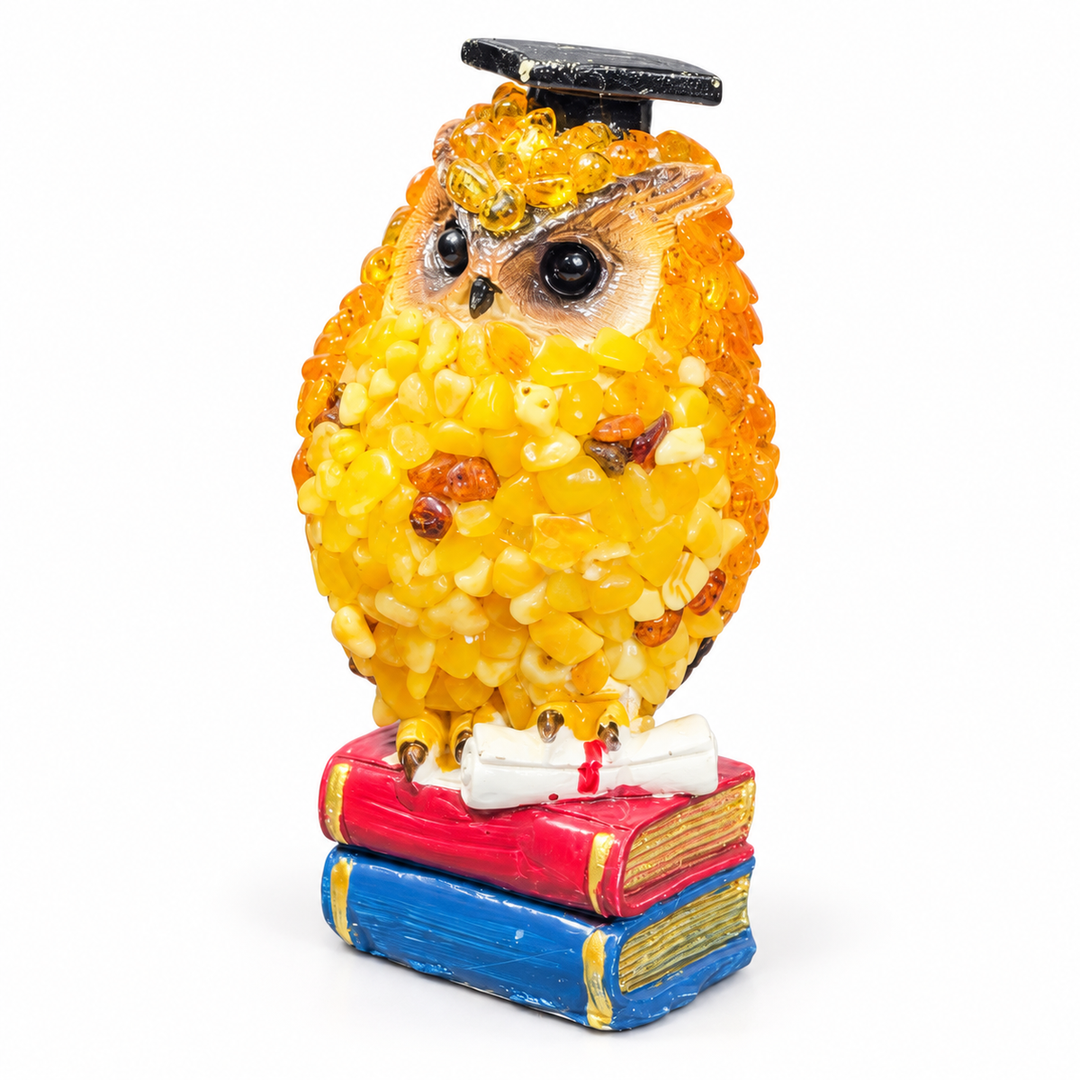 Three-quarter view of the handmade Baltic amber graduation owl with a sparkling textured surface on a white background.