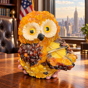 Made in USA natural Baltic amber violinist owl figurine on an oak desk in an American office with a Manhattan view.