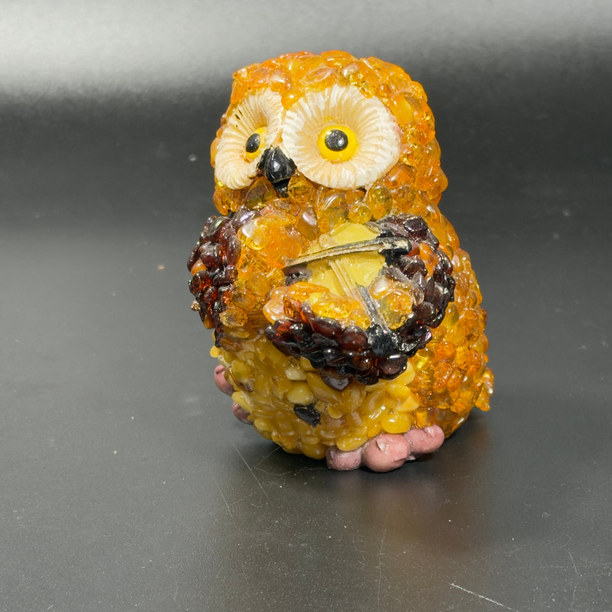 Right three-quarter view of the Brooklyn-made amber owl showing the violin and bow on the strings.