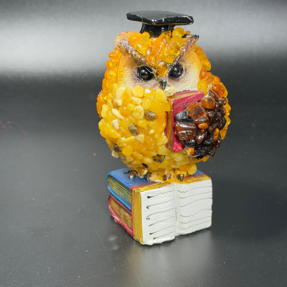 Front photo of the reading owl showing the black graduation cap, red book and open-book base.
