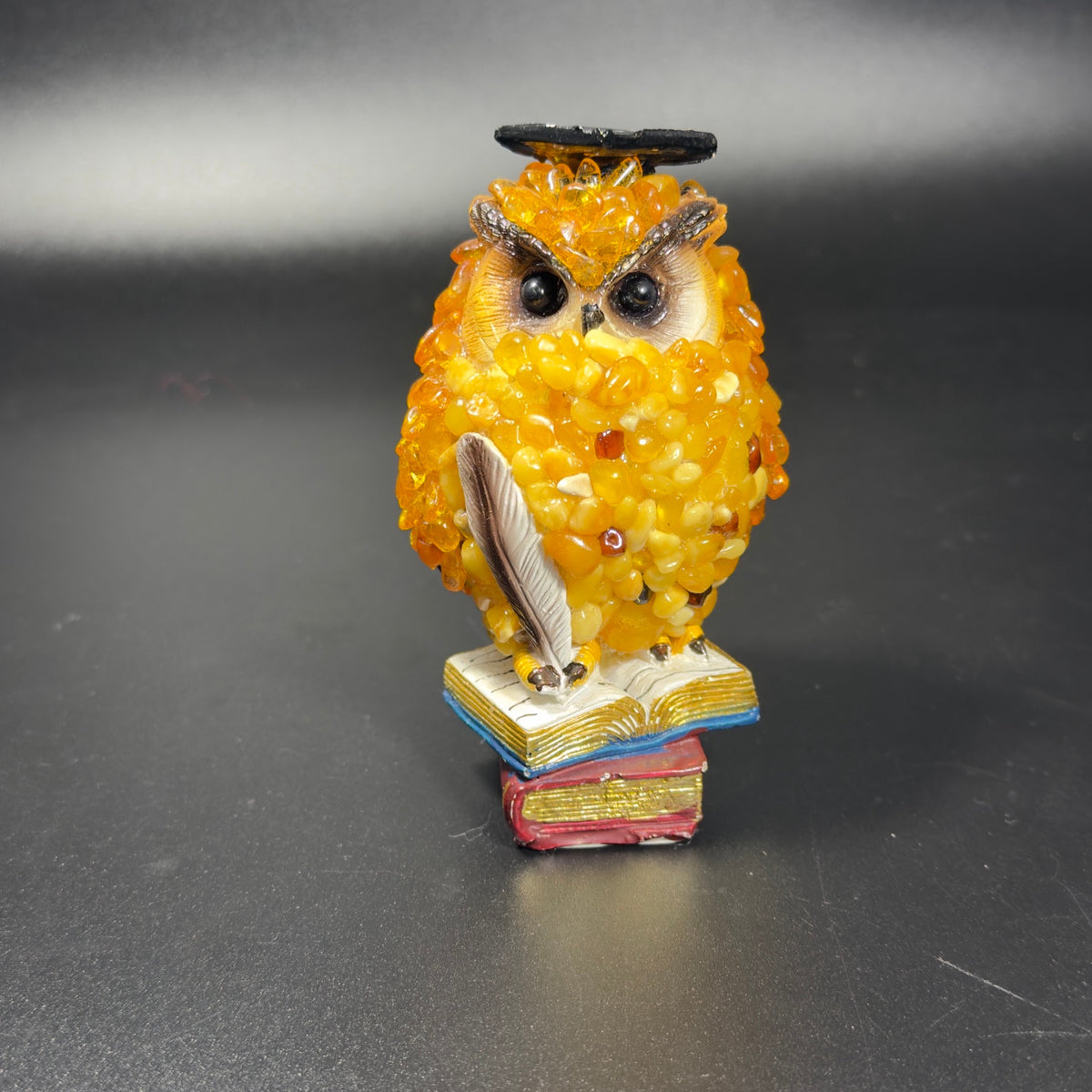Original photograph of golden-yellow scholar owl figurine with mortarboard, feather quill and stacked books, SKU 49OWL07Q116-11-7-7