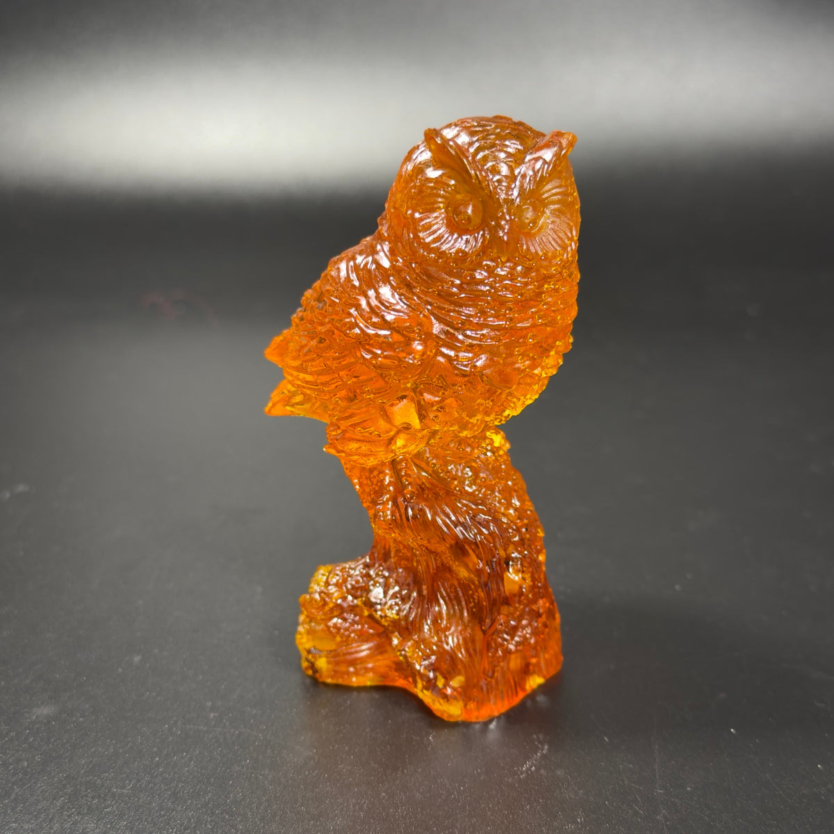 Original front three-quarter photograph of the orange owl on a dark tabletop
