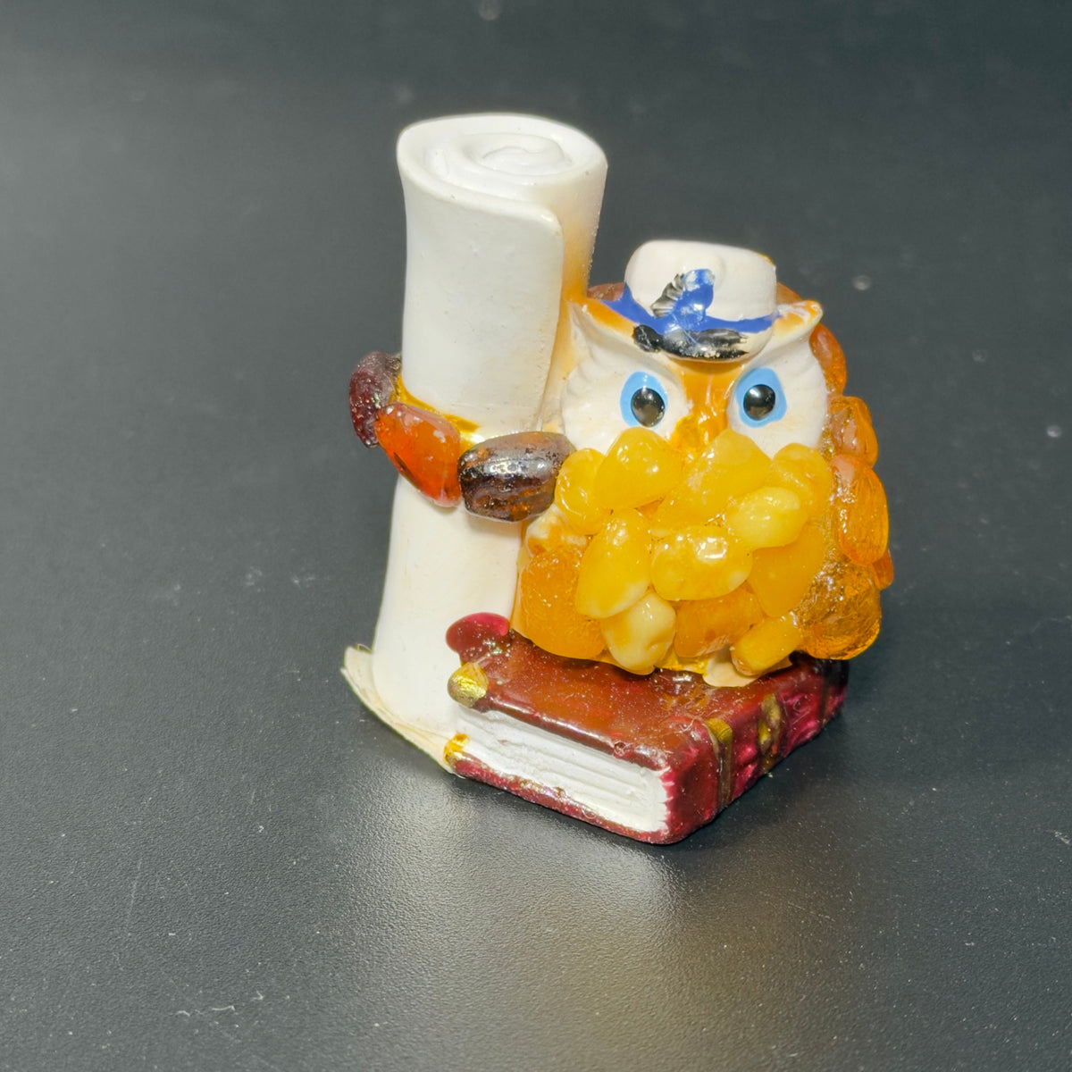 Original front photograph of owl figurine with scroll and burgundy book