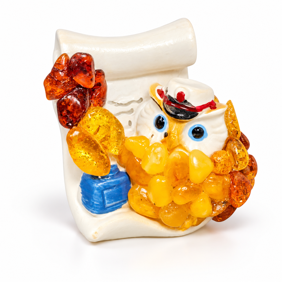 Front detail of the capped owl figurine with blue eyes and a cream scroll on white