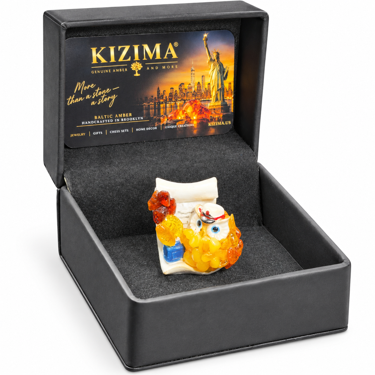 Owl figurine inside its open black KIZIMA presentation box on white