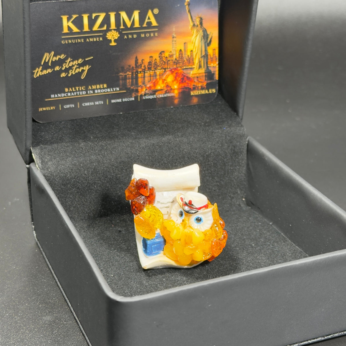 Original photograph of the owl figurine inside the open KIZIMA presentation box