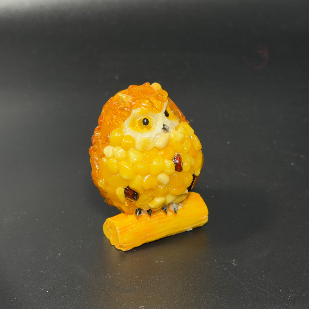 Original photograph of the yellow owl figurine on its log-shaped base