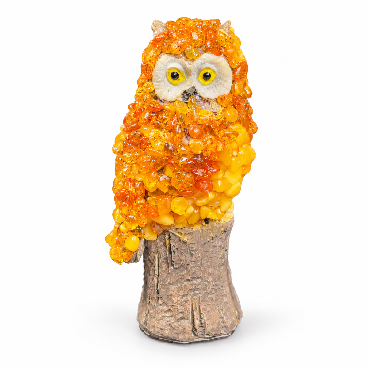 Front view of handmade amber owl with ear tufts, cream face and yellow eyes on a brown stump, white background