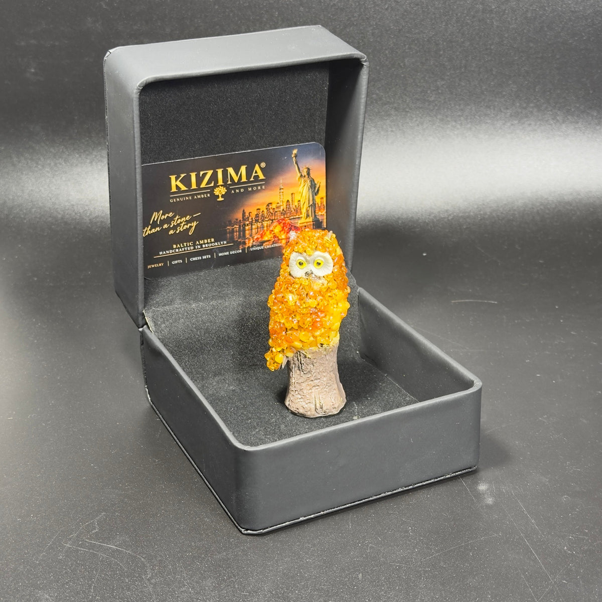 Unedited photo of the amber owl figurine resting in its actual black presentation box
